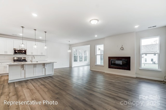 8619 Frank Grier Rd Unit 3, Charlotte, NC 28215 - unfurnished living room with a sink, recessed lighting, dark wood-type flooring, baseboards, and a glass covered fireplace
