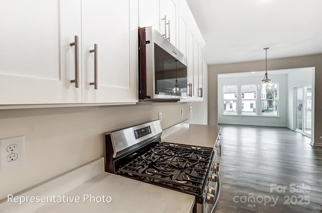 8619 Frank Grier Rd Unit 3, Charlotte, NC 28215 - kitchen with appliances with stainless steel finishes, white cabinets, dark wood-style flooring, hanging light fixtures, and light countertops