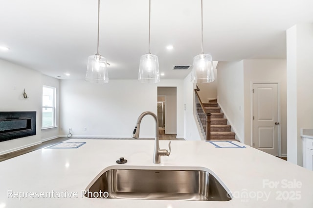 8619 Frank Grier Rd Unit 3, Charlotte, NC 28215 - kitchen with a sink, light countertops, a glass covered fireplace, decorative light fixtures, and recessed lighting