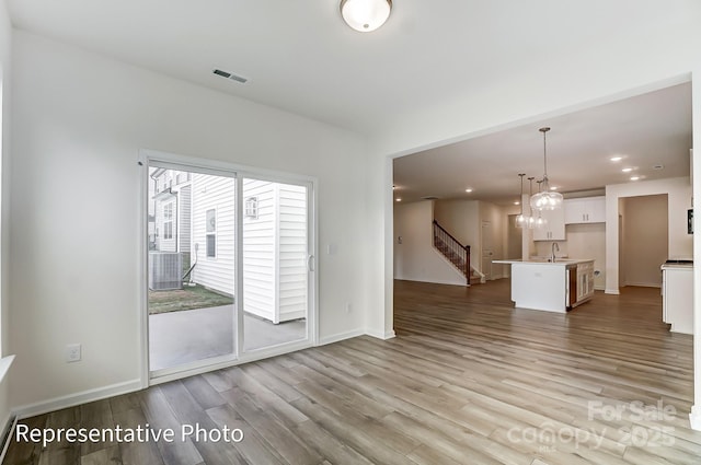 8619 Frank Grier Rd Unit 3, Charlotte, NC 28215 - unfurnished living room with a sink, wood finished floors, stairway, baseboards, and recessed lighting