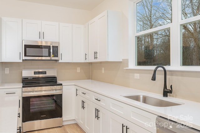 318 Sixth St, Belmont, NC 28012 - kitchen featuring appliances with stainless steel finishes, a sink, light countertops, and white cabinetry