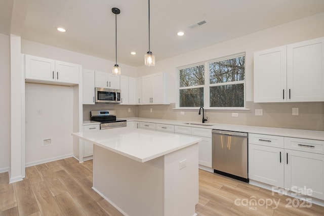 318 Sixth St, Belmont, NC 28012 - kitchen featuring appliances with stainless steel finishes, a sink, tasteful backsplash, light wood finished floors, and white cabinets