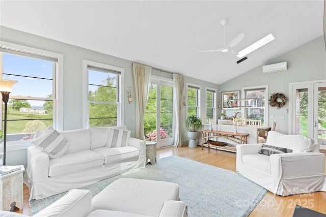 sunroom / solarium featuring a wall unit AC, lofted ceiling, a skylight, and healthy amount of natural light