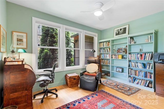 office featuring wood finished floors, a ceiling fan, and baseboards