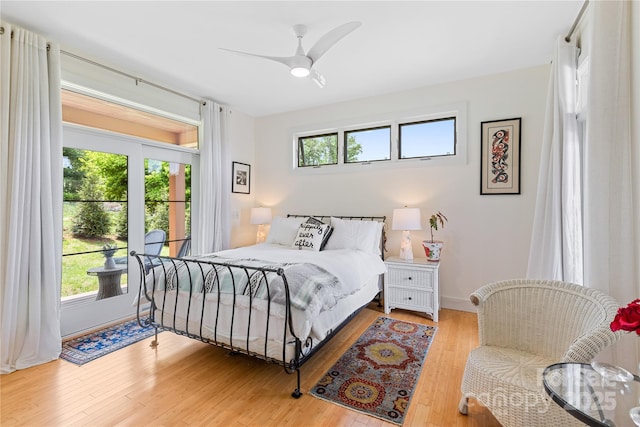 bedroom featuring multiple windows, light wood finished floors, baseboards, and ceiling fan