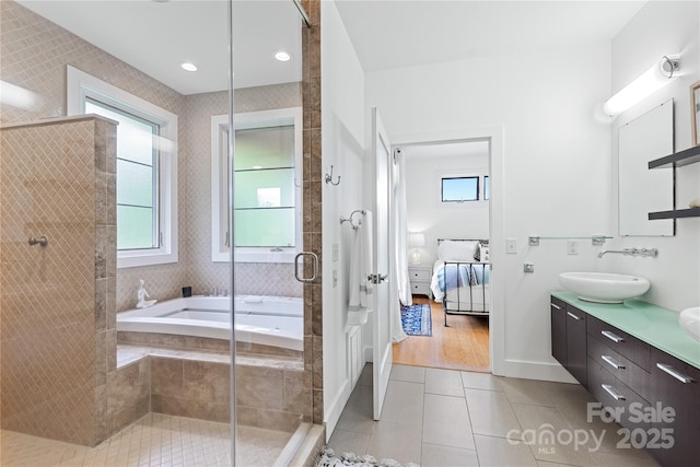 bathroom featuring ensuite bathroom, tile patterned floors, double vanity, tiled shower, and a bath