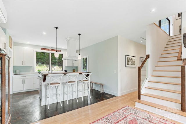 kitchen featuring a breakfast bar area, plenty of natural light, white cabinets, hanging light fixtures, and recessed lighting