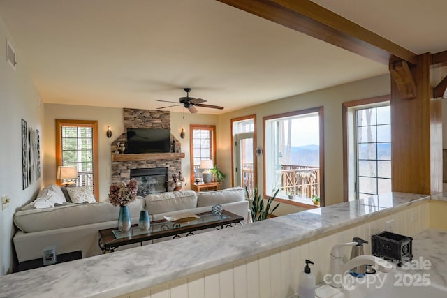 61 Creekside Way Unit G/101, Burnsville, NC 28714 - living area with a stone fireplace, a ceiling fan, and plenty of natural light