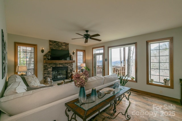 61 Creekside Way Unit G/101, Burnsville, NC 28714 - living area with a ceiling fan, a stone fireplace, light wood-style flooring, and baseboards