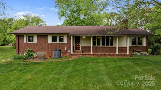 1 Ola Dr, Candler, NC 28715 - single story home with central AC, a front lawn, brick siding, and a chimney