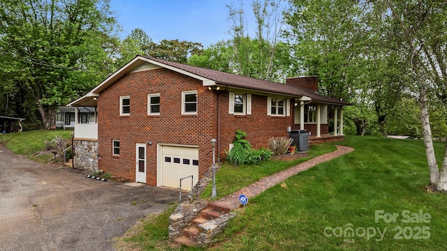 1 Ola Dr, Candler, NC 28715 - view of home's exterior with a chimney, asphalt driveway, a yard, an attached garage, and brick siding