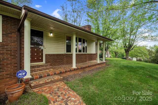 1 Ola Dr, Candler, NC 28715 - view of exterior entry featuring brick siding, a lawn, and a chimney