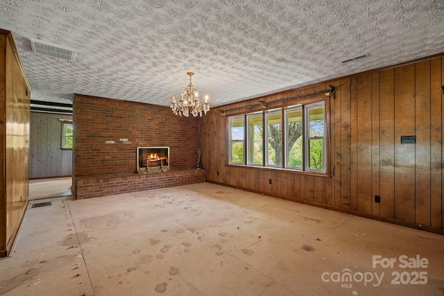 1 Ola Dr, Candler, NC 28715 - unfurnished dining area with a brick fireplace, a chandelier, baseboards, and wooden walls