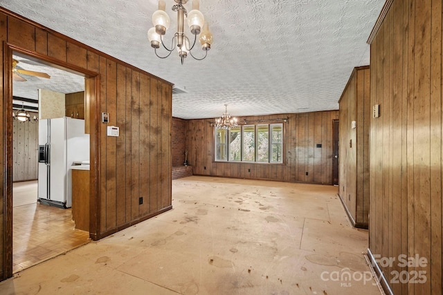 1 Ola Dr, Candler, NC 28715 - unfurnished room featuring a chandelier, a textured ceiling, and wood walls