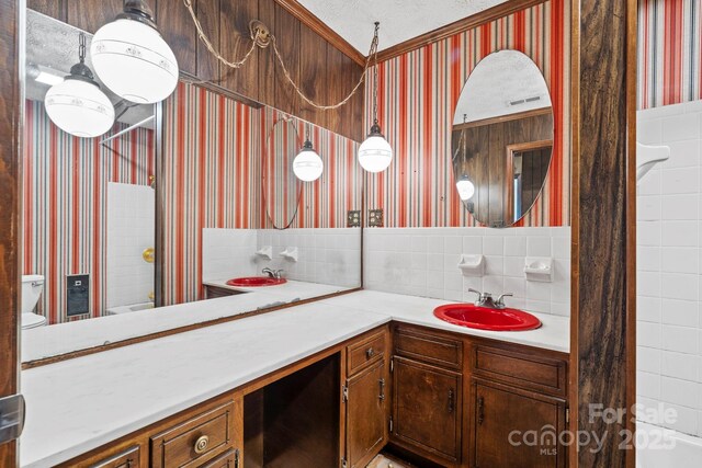 1 Ola Dr, Candler, NC 28715 - bathroom with wallpapered walls, vanity, toilet, and decorative backsplash