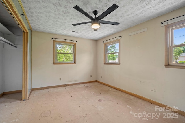 1 Ola Dr, Candler, NC 28715 - unfurnished bedroom featuring baseboards, multiple windows, a textured ceiling, and a ceiling fan