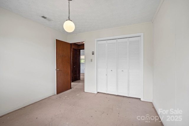 1 Ola Dr, Candler, NC 28715 - unfurnished bedroom featuring a closet, baseboards, and a textured ceiling