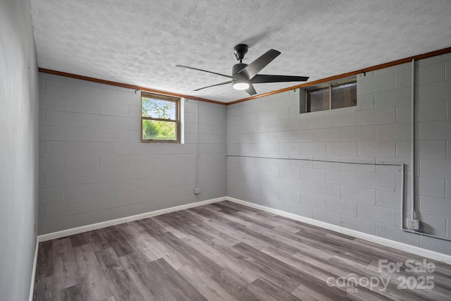 1 Ola Dr, Candler, NC 28715 - spare room featuring a textured ceiling, a ceiling fan, concrete block wall, wood finished floors, and baseboards