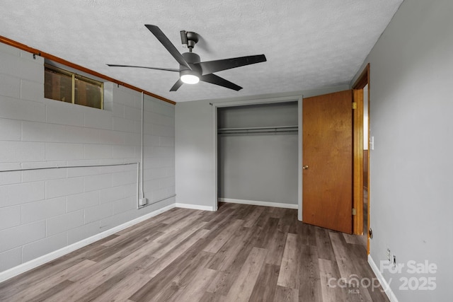 1 Ola Dr, Candler, NC 28715 - unfurnished bedroom with wood finished floors, a textured ceiling, a closet, baseboards, and ceiling fan