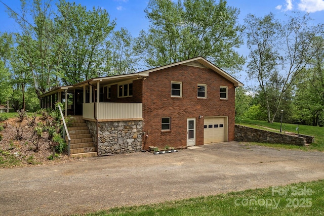 1 Ola Dr, Candler, NC 28715 - view of property exterior with driveway, stairs, stone siding, a garage, and brick siding