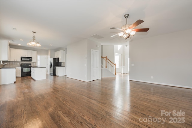 10008 King George Ln, Waxhaw, NC 28173 - unfurnished living room featuring a ceiling fan, dark wood-style floors, a chandelier, baseboards, and recessed lighting