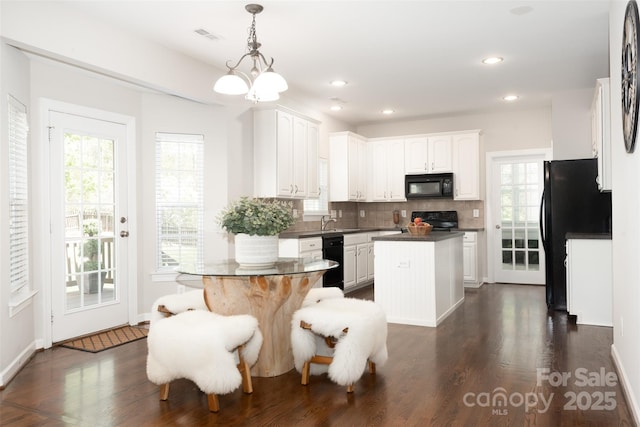 10008 King George Ln, Waxhaw, NC 28173 - kitchen with black appliances, dark countertops, a center island, backsplash, and plenty of natural light