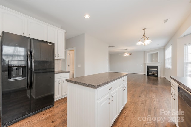 10008 King George Ln, Waxhaw, NC 28173 - kitchen with black refrigerator with ice dispenser, stainless steel dishwasher, dark countertops, white cabinetry, and ceiling fan