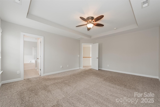 10008 King George Ln, Waxhaw, NC 28173 - unfurnished bedroom featuring a raised ceiling, light colored carpet, baseboards, ensuite bath, and a ceiling fan