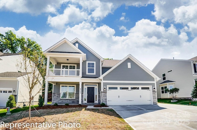 craftsman inspired home with a balcony, driveway, stone siding, and an attached garage
