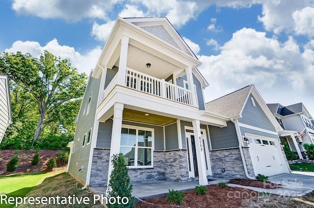 view of front of home featuring a balcony, a porch, a garage, driveway, and stone siding