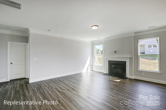 unfurnished living room featuring ornamental molding, dark wood-type flooring, baseboards, and a glass covered fireplace