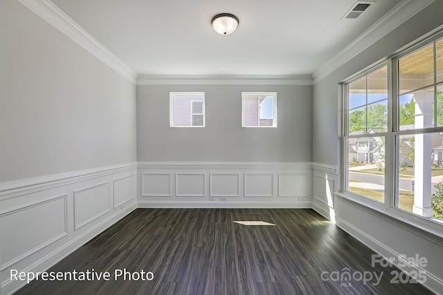 spare room with a wainscoted wall, dark wood-style flooring, and crown molding
