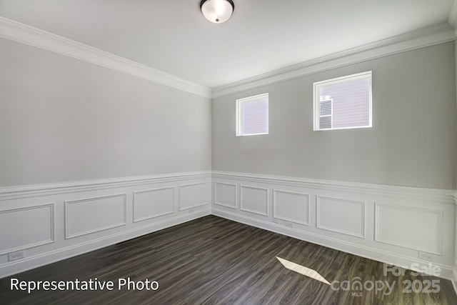 unfurnished room featuring ornamental molding, a wainscoted wall, dark wood-style floors, and a decorative wall