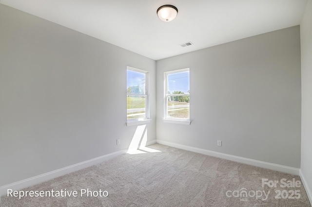 carpeted spare room featuring baseboards
