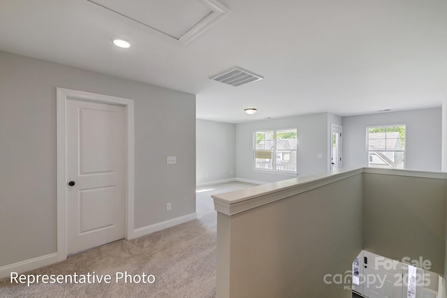 hall with plenty of natural light, light carpet, baseboards, and recessed lighting