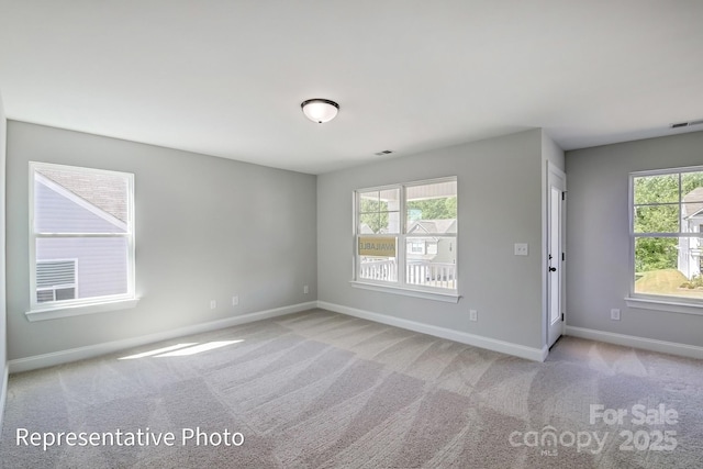 empty room with plenty of natural light, baseboards, and carpet