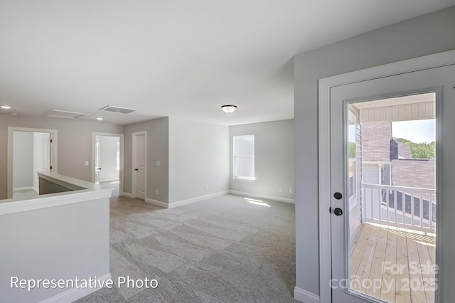 empty room featuring baseboards, recessed lighting, and light colored carpet