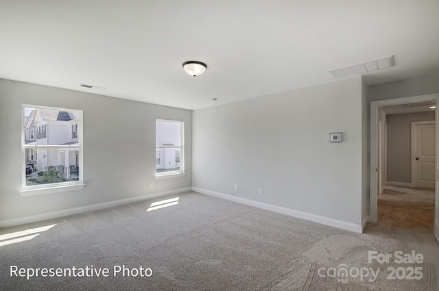carpeted empty room featuring healthy amount of natural light and baseboards