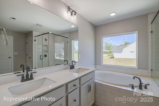 full bathroom with a stall shower, a garden tub, double vanity, and recessed lighting