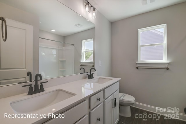 full bath featuring toilet, a shower, double vanity, baseboards, and wood finished floors