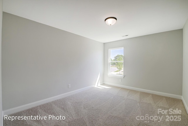 carpeted empty room with baseboards