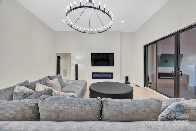 1141 Harper Lee Dr, Newton, NC 28658 - living room with a chandelier, wood finished floors, a glass covered fireplace, recessed lighting, and a towering ceiling