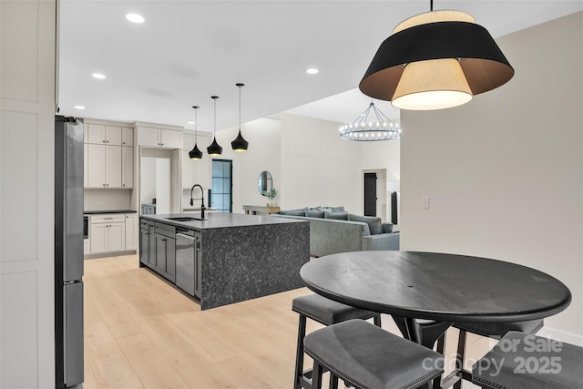 1141 Harper Lee Dr, Newton, NC 28658 - kitchen with stainless steel dishwasher, freestanding refrigerator, dark countertops, light wood-style flooring, and recessed lighting