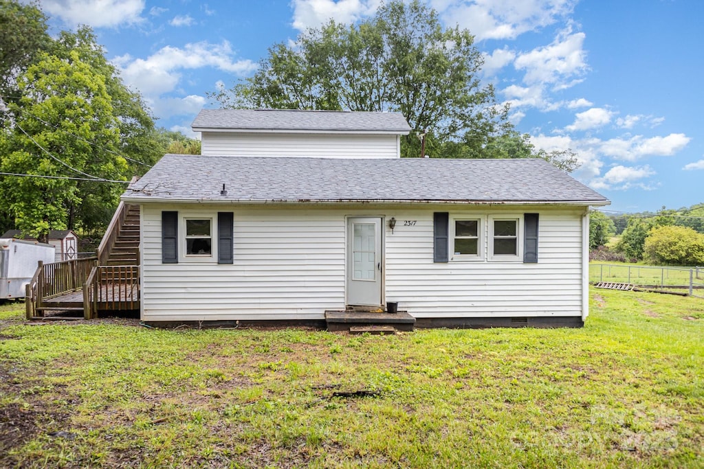 view of front facade featuring a shingled roof, crawl space, and stairs