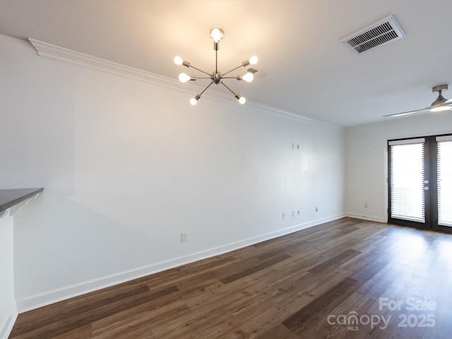 unfurnished dining area featuring crown molding, a chandelier, baseboards, dark wood finished floors, and ceiling fan