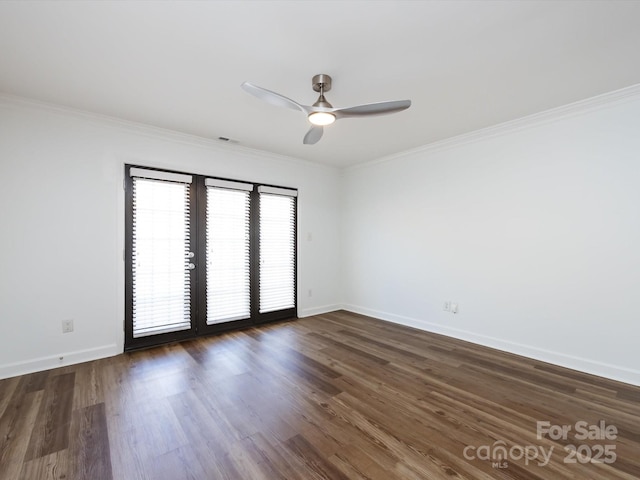 empty room with a ceiling fan, baseboards, dark wood-type flooring, and ornamental molding