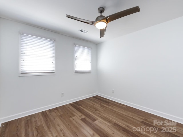 spare room featuring wood finished floors, a ceiling fan, and baseboards