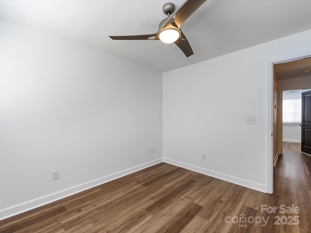 unfurnished room with dark wood-style floors, a ceiling fan, and baseboards