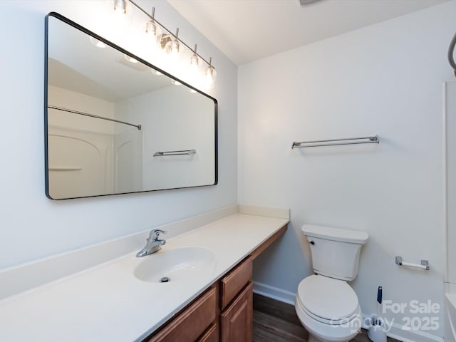 full bath with vanity, toilet, baseboards, and wood finished floors