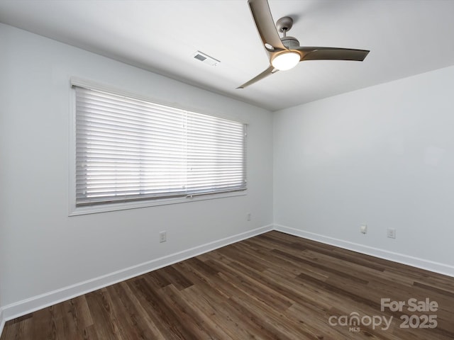empty room featuring wood finished floors, a ceiling fan, and baseboards